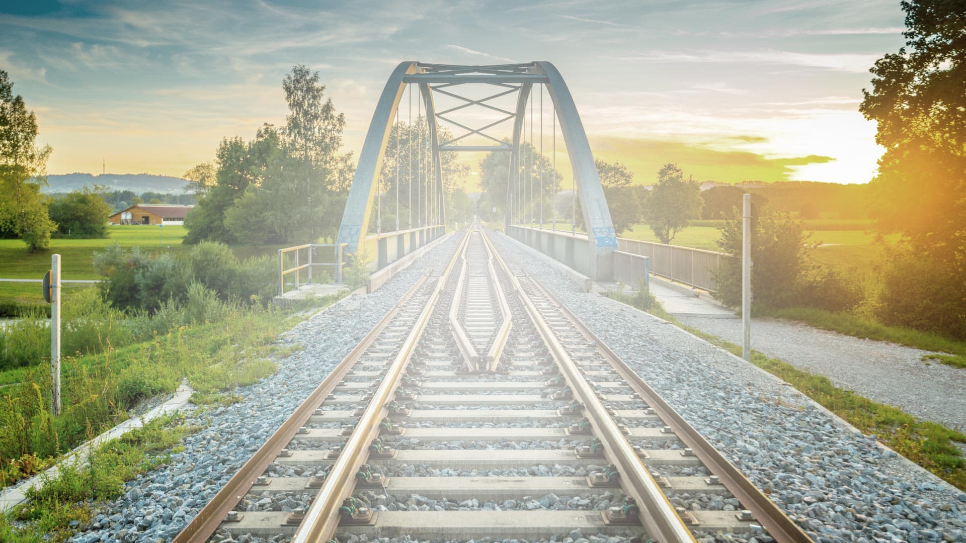 Railway track crossing an arched bridge at sunset